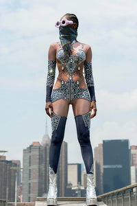 Bold festival bodysuit with rhinestones, sheer panels & leg warmers by HARMONIA NY, city skyline backdrop